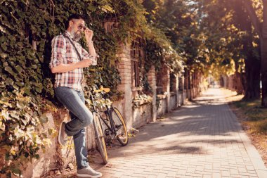 Bisiklet kahve ile yanındaki duvara karşı duran ve uzağa düşünce gözlük arıyorum rahat iş adamı.