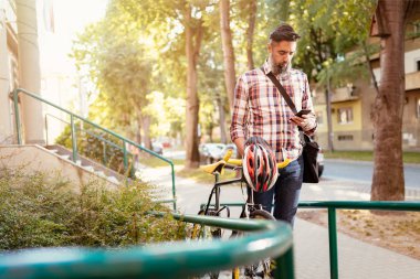 Casual işadamı bisikletle işe yarayacak. O bisiklet iterek ve kısa mesaj gönderme.