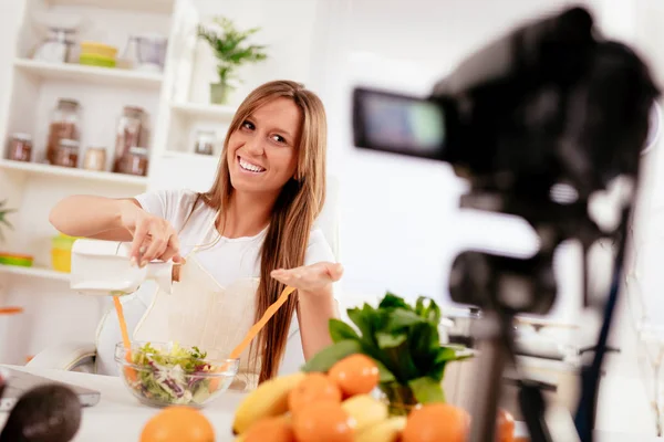 彼女のブログの撮影の美しい若い女性が自宅で健康食品について放送 — ストック写真