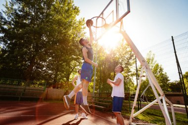 Genç basketbolcular sokak sahada bir eğitim var. Onlar oynarken ve birlikte eylem yapma. Genç adam delik için topu atmak. 