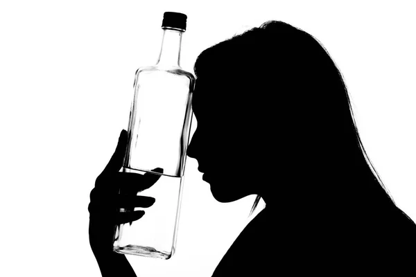 一个年轻的喝醉了的女人与玻璃瓶的剪影 — 图库照片