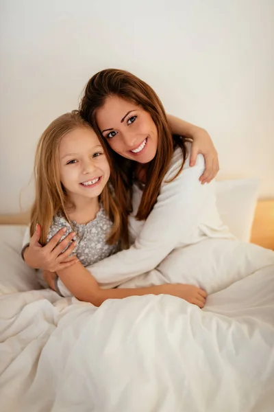 Vackra Leende Mor Och Hennes Dotter Som Kramas Sängen Sitter — Stockfoto