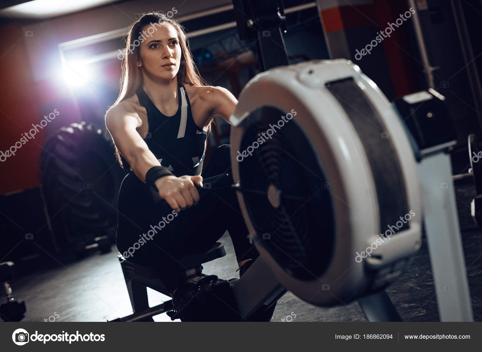 Woman pulling the rowing machine — Stock Photo © MilanMarkovic 186862094