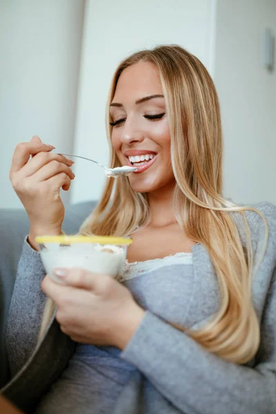 Woman eating cereal with yogurt — Stock Photo, Image