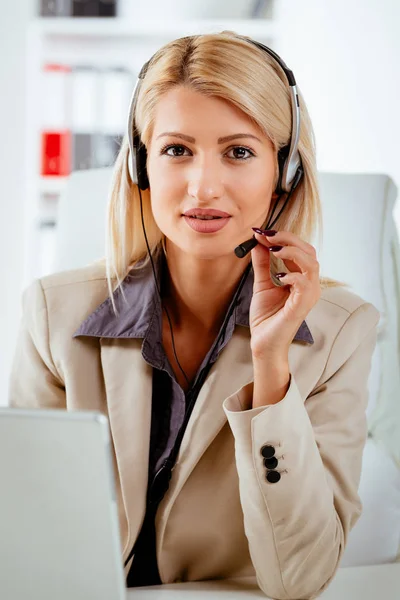 Mujer sentada en la oficina con un auricular — Foto de Stock