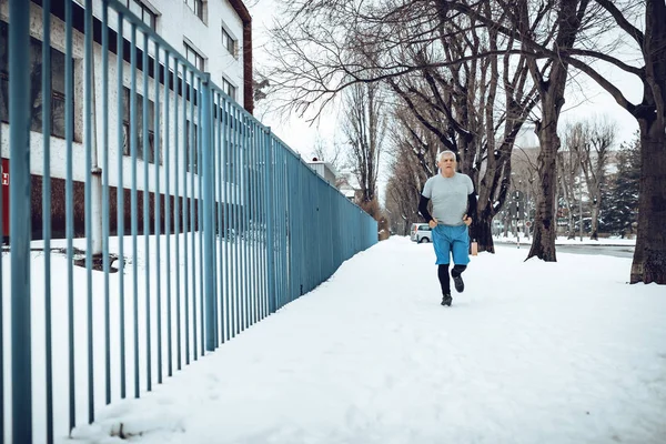 Активный Пожилой Человек Бегает Делает Упражнения Забора Время Зимних Тренировок — стоковое фото