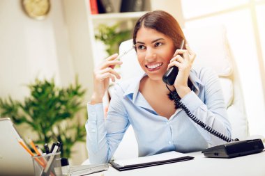 Smartphone kullanıyorsanız ve Office masada çalışıyorsanız başarılı genç kadın. 