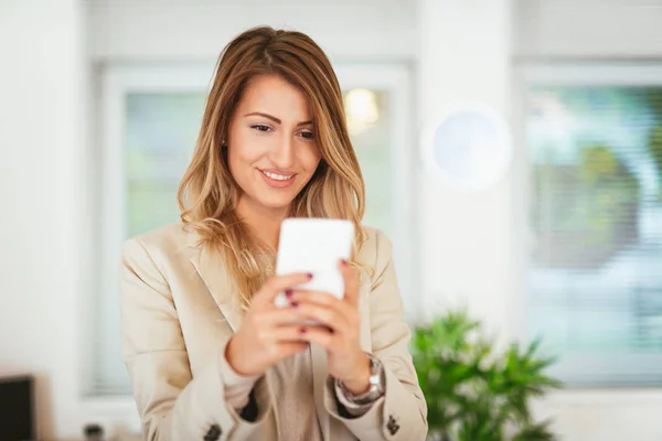 Junge Hübsche Lächelnde Geschäftsfrau Die Büro Auf Dem Smartphone Sms — Stockfoto