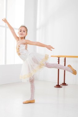 Bale pratik ve kameraya bakarak sevimli küçük kız.