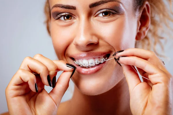 Close Uma Menina Sorridente Com Aparelho Limpeza Dentes Com Fio — Fotografia de Stock