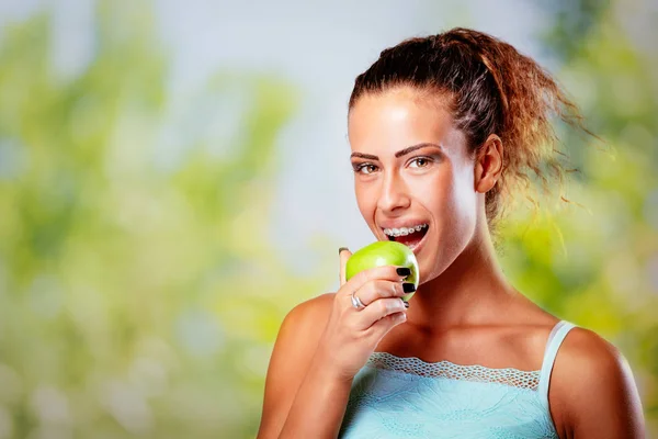 Χαμογελώντας Νεαρή Γυναίκα Τιράντες Για Λευκά Δόντια Κρατώντας Πράσινο Μήλο — Φωτογραφία Αρχείου