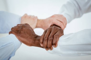 sıkı bir şekilde bir arada tutan dört siyah beyaz el
