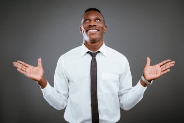 Gri arka plan üzerinde ararken gülümseyen Afrika işadamı