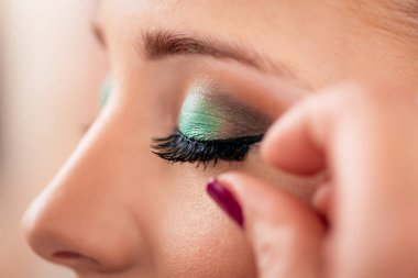 Modellemek için makyaj sanatçısı yanlış eyelashes uygulayarak görünümünü kapat