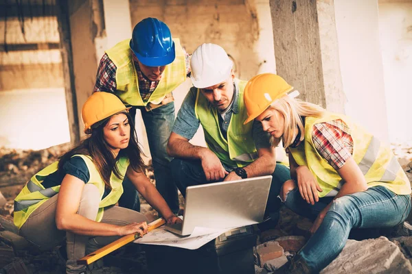 Four Construction Architects Review Building Plan Reconstruction Damaged Disaster — Stock Photo, Image