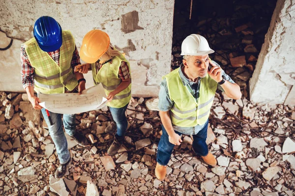 Three Construction Architects Review Building Plan Reconstruction Damaged Disaster — Stock Photo, Image
