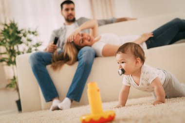 Eğleniyor ve evde oynarken güzel bebek çocuk. Ailesi onu arıyor ve zevk.