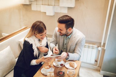 Tatilinde kafede dizüstü bilgisayar üzerinde çalışan iki güzel gülümseyen iş adamları