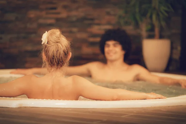 young couple relaxing in spa-center in hot tube
