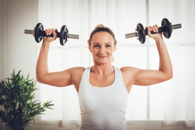 kaslı kadın TV online kişisel antrenörle dumbbells ile egzersiz yaparak