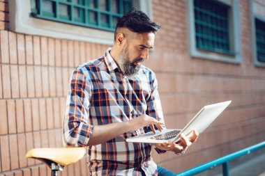 casual işadamı Bisiklet yanındaki bina ve dizüstü bilgisayarda çalışma önünde duran 