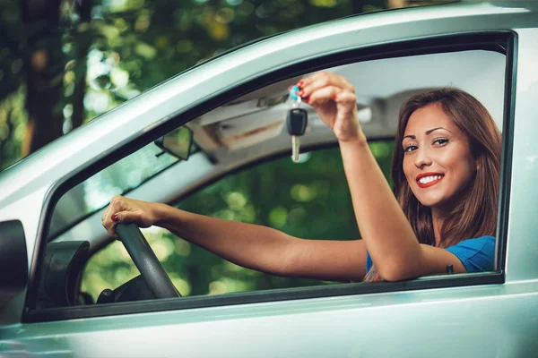 若者の車ドライバー女性笑顔と車のキーを示す — ストック写真