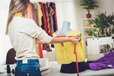 Genç kadın manken mezura ile üzerinde giyim tedbir almak