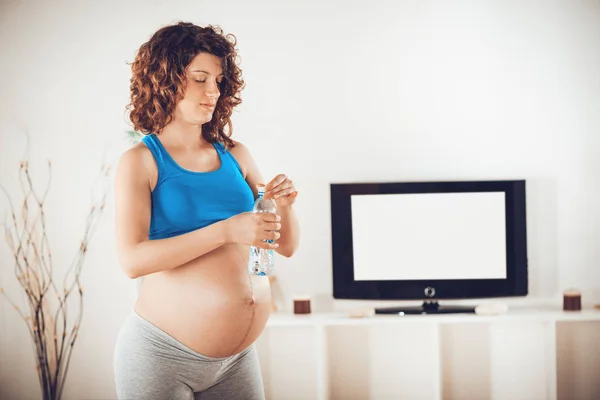 Mujer Embarazada Joven Sosteniendo Botella Agua Relajándose Casa Después Ejercicios — Foto de Stock