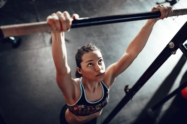 spor salonunda pull-up egzersiz yaparak genç kaslı kadın