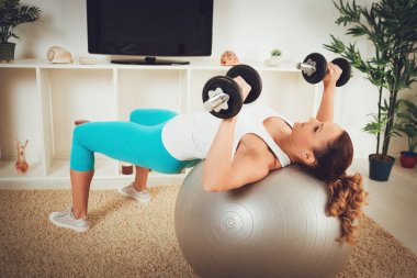 kaslı kadın TV online kişisel antrenörle dumbbells ile egzersiz yaparak