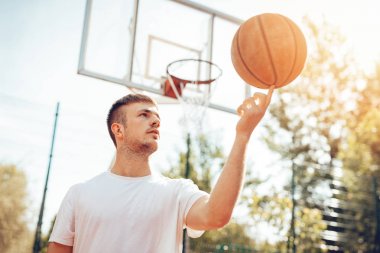 Genç sokak basketbol oyuncu dönen topu üstünde parmak