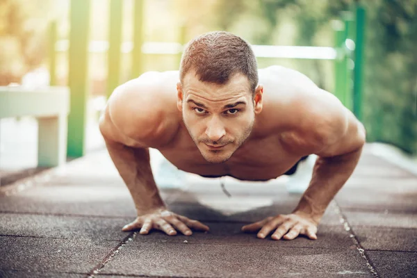 Young sportsman doing push-up exercise outdoor