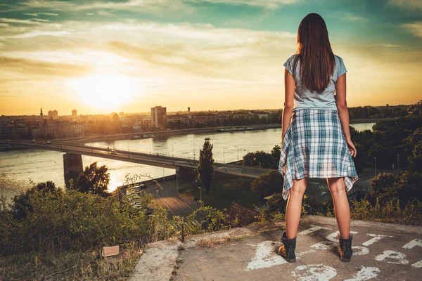 Bakifrån Ung Kvinna Njuter Solnedgången Över Staden Och Floden — Stockfoto