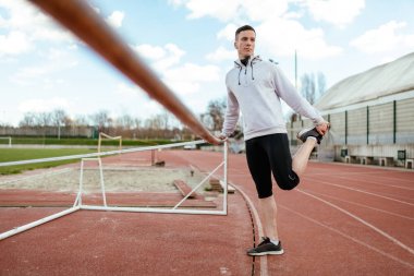 Aktif genç germe bacaklar üzerinde boş Stadyumu koşu daha önce adam