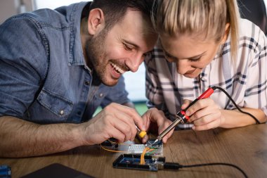 İki genç iş ortakları teknisyen elektronik donatımın tamiri üzerinde duruldu