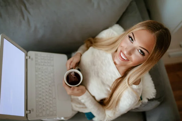 Lächelnde Frau Sitzt Mit Tasse Tee Wohnzimmer Und Benutzt Laptop — Stockfoto