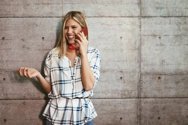 年轻成功女企业家谈智能手机在混凝土墙前 — 图库照片