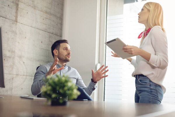 Young business colleagues arguing at workplace