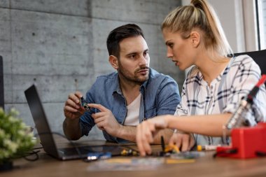 İki genç iş ortakları teknisyen elektronik donatımın tamiri üzerinde duruldu