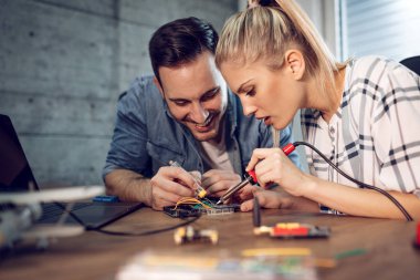 İki genç iş ortakları teknisyen elektronik donatımın tamiri üzerinde duruldu