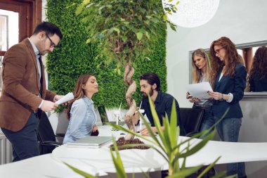 Grup genç mühendis konusunda alternatif enerji projesi Minyatürler yel türbinleri ile masada konuşurken