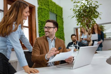 Ofiste çalışan ve kahve molası sırasında yeşil proje hakkında konuşurken genç girişimciler