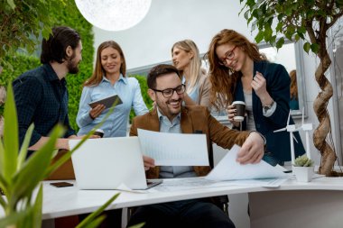 Grup genç mühendis konusunda alternatif enerji projesi Minyatürler yel türbinleri ile masada konuşurken