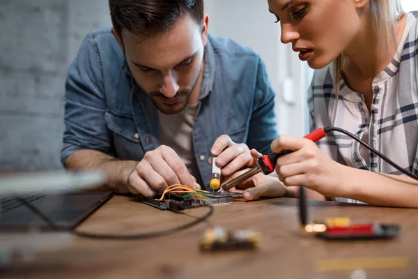 两位年轻的商业伙伴技术员专注于修理电子设备 — 图库照片