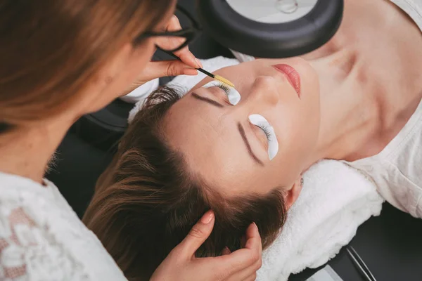 Kosmetolog Tillämpa Längre Ögonfransar Ung Kvinna Skönhetssalong — Stockfoto
