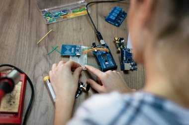 Üstten Görünüm bir kadın tarafından havya masada lehimleme devre kartı eller.