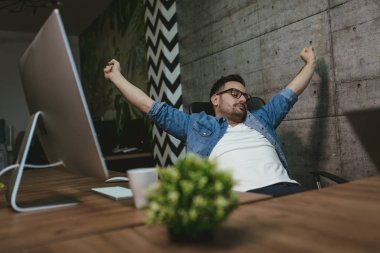 Genç yakışıklı office germe ve çalışma saatleri sonu bekleyen oturan işadamı overworked. 