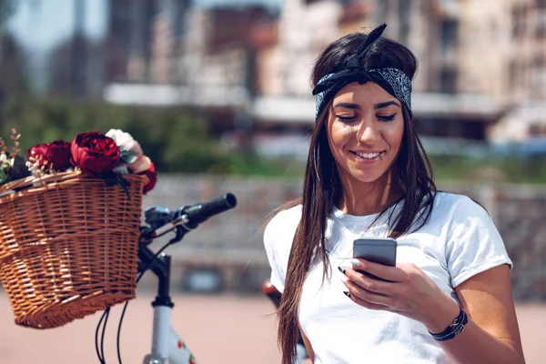 Uśmiechający Się Młoda Kobieta Sms Inteligentnego Telefonu Miasto Ulica Słoneczny — Zdjęcie stockowe