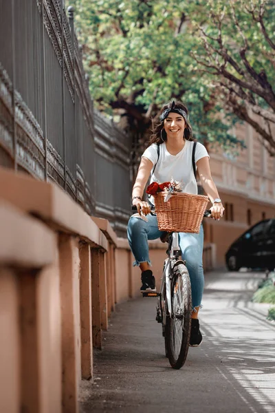 夏の晴れた日に ストリート街に沿って自転車に乗って幸せな女の野外活動中に喜びの笑みを浮かべて — ストック写真