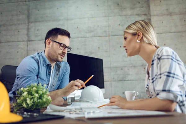 Jóvenes Colegas Pensativos Del Arquitecto Analizando Planos Hablando Oficina —  Fotos de Stock